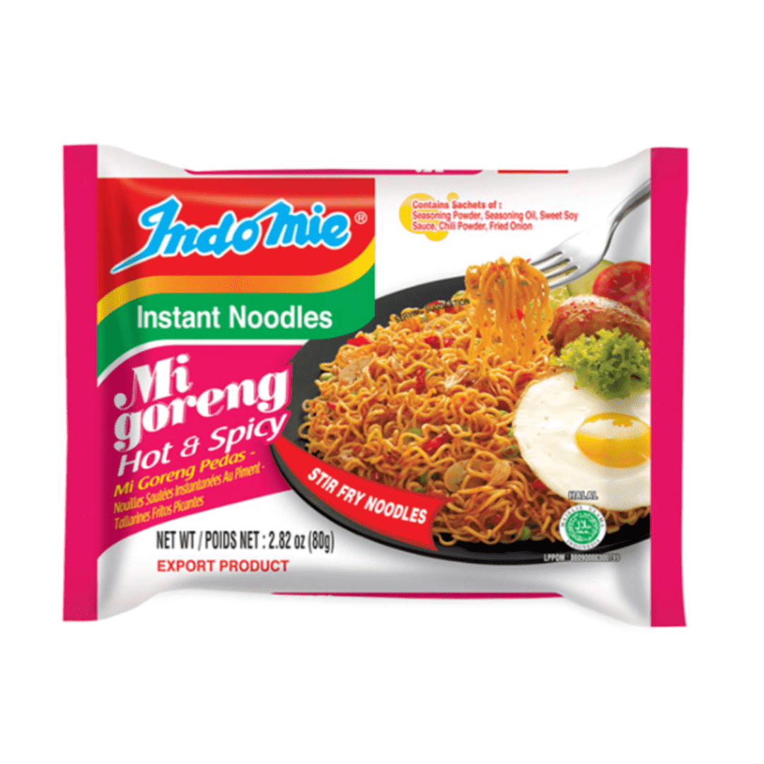 Package of Indomie Migoreng hot and spicy fried noodles with a photo of cooked noodles topped with an egg, lettuce, and tomatoes.
