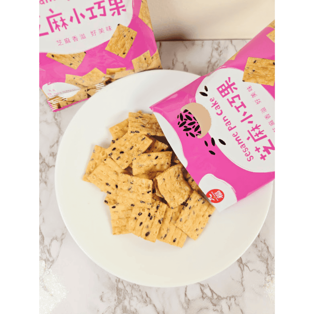 Sesame crackers on a plate with pink packaging on a marble surface