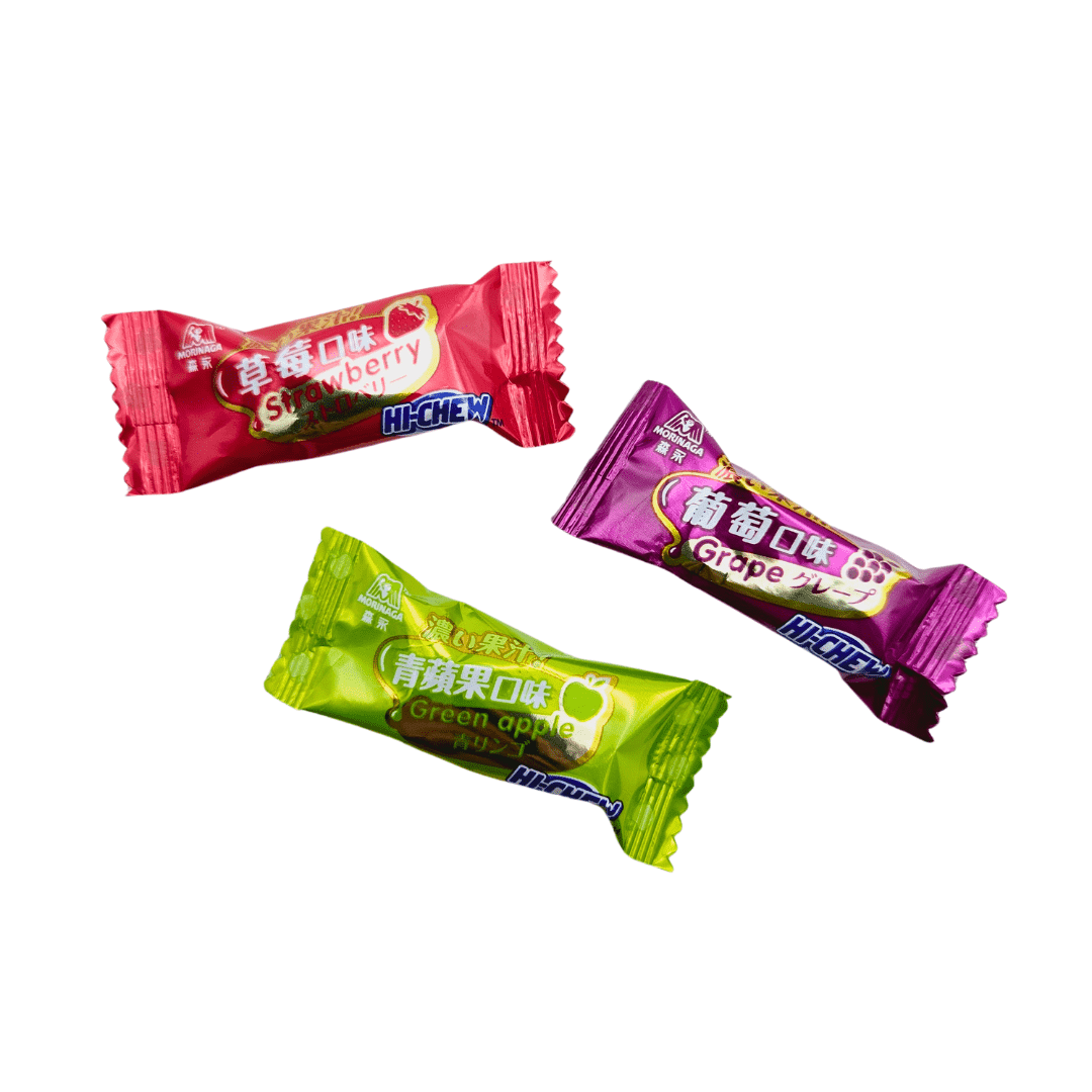 Three Hi-Chew candies in different flavors. The red wrapper is Strawberry flavor, the purple wrapper is Grape flavor, and the green wrapper is Green Apple flavor.